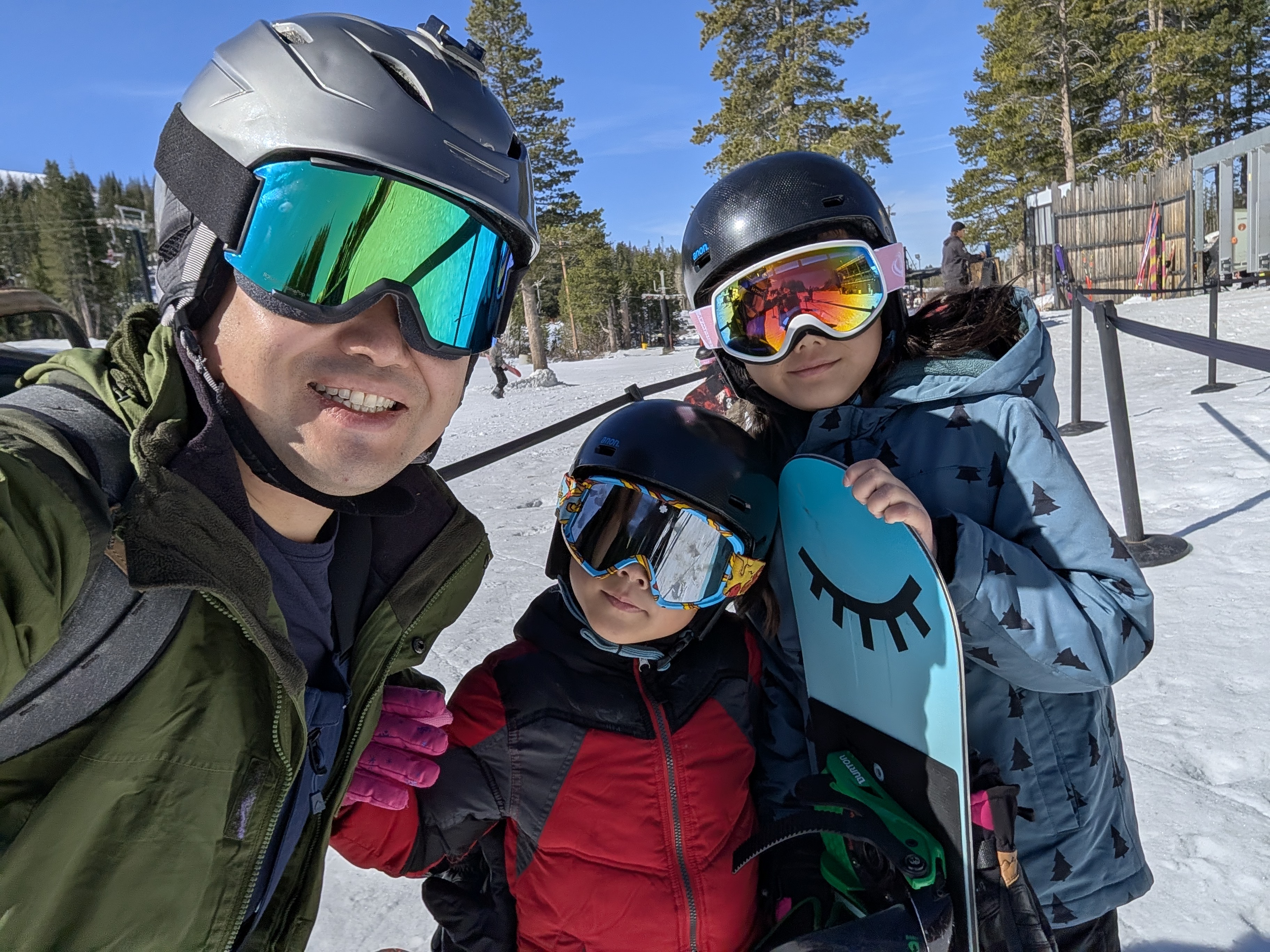 Nick on the mountain with two of his kids in ski gear